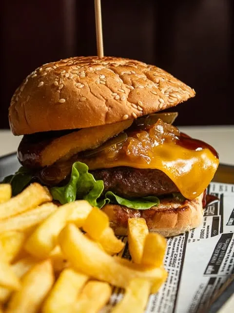 Su hamburguesa con cheddar fundido, aro de cebolla y patatas, en el local